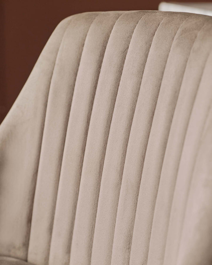 Close-up of a beige velvet chair back with vertical channel tufting. Soft texture and elegant design detail.