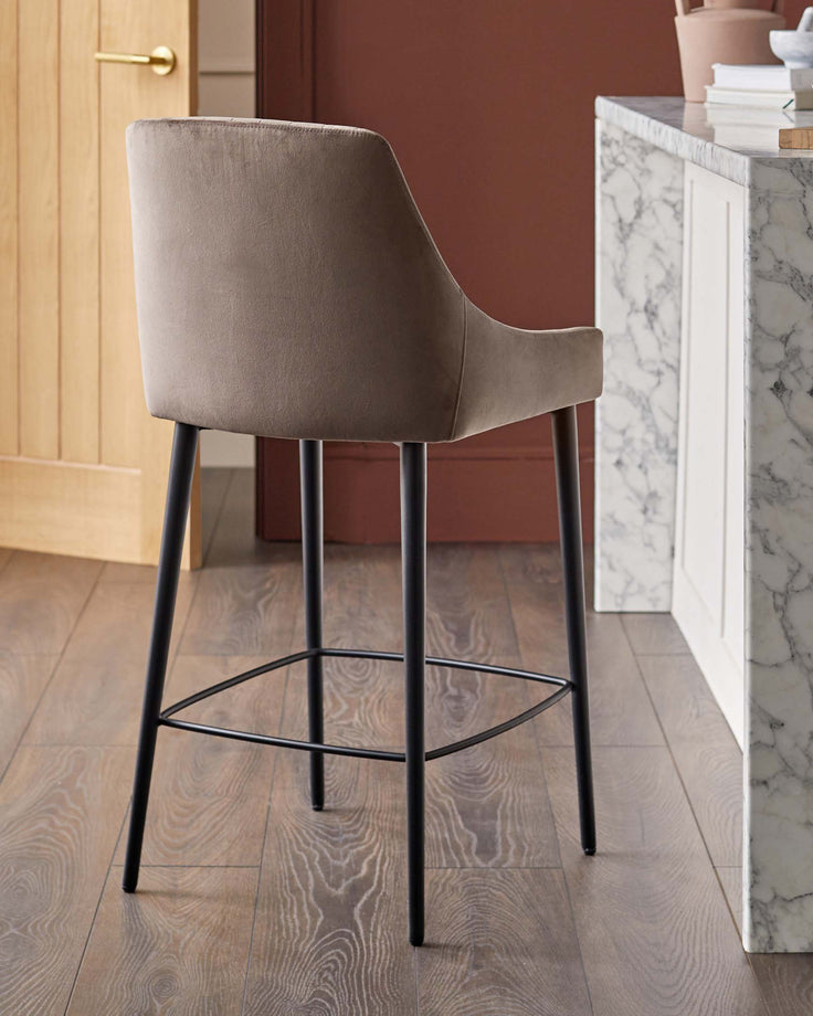 A stylish, brown bar stool with a metal base and a soft, upholstered seat, perfect for modern kitchens.