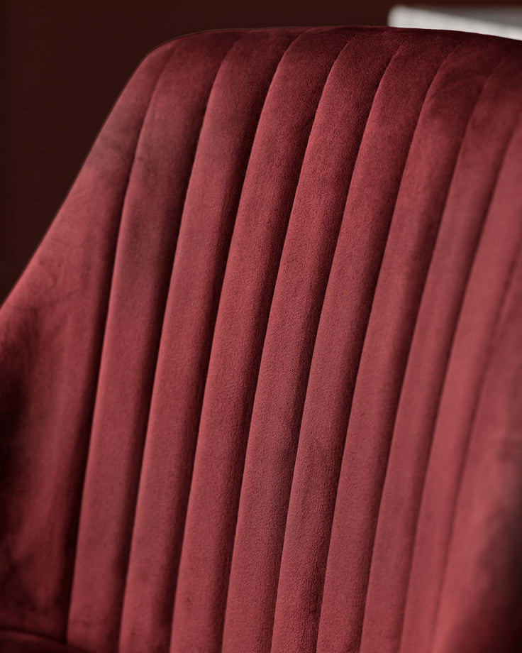 Close-up of a red velvet chair with ribbed design. Luxurious and stylish seating option for any modern living space.
