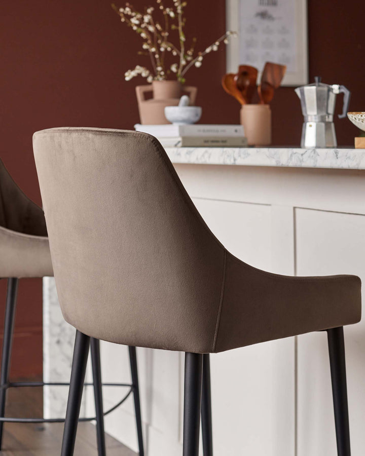 Close up of a stylish bar stool with a cushioned seat and backrest, paired with sleek, black legs.