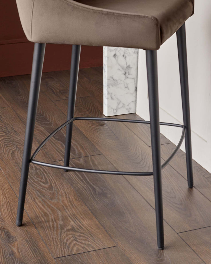 Close-up of a stylish bar stool with a brown seat and sleek black legs, perfect for modern kitchen designs.