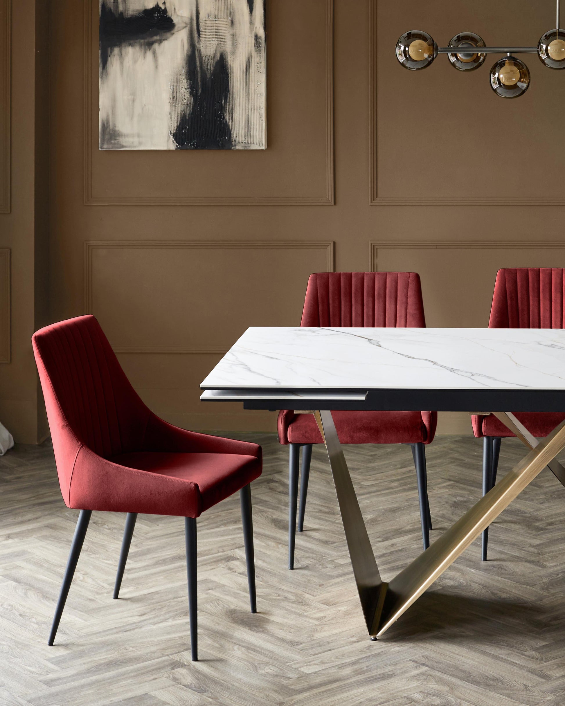 A stylish dining set with a marble table, gold base, and burgundy velvet chairs, creating an elegant and modern dining space.