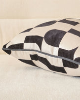 Black and cream checkered medium cushion with gray piping detail, angled side view.