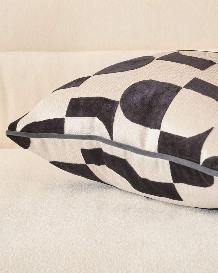 Black and cream checkered medium cushion with gray piping detail, angled side view.
