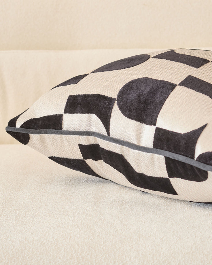 Black and cream checkered medium cushion with gray piping detail, angled side view.