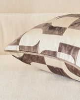 Bridget cushion in chocolate and cream checkered pattern, shown at an angle on a neutral surface.