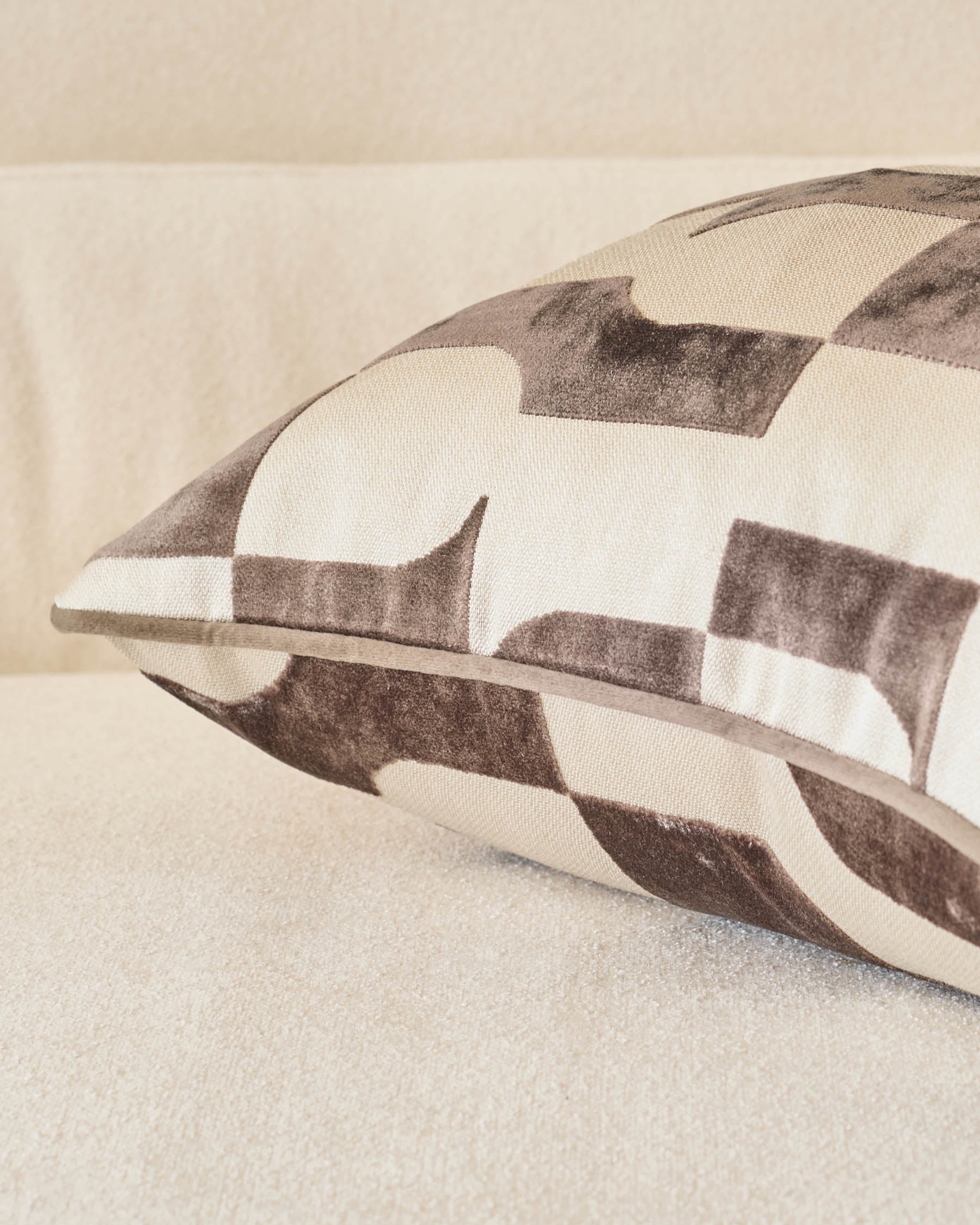 Bridget cushion in chocolate and cream checkered pattern, shown at an angle on a neutral surface.