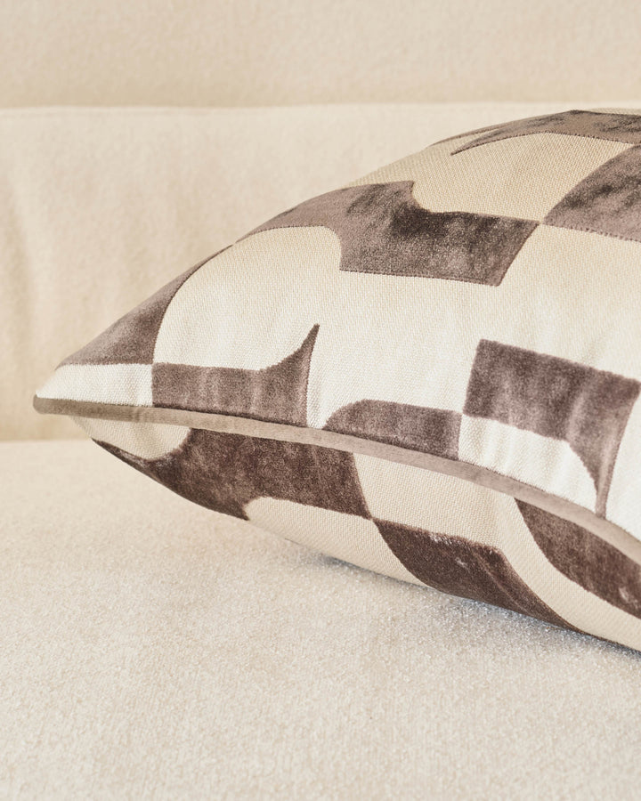 Bridget cushion in chocolate and cream checkered pattern, shown at an angle on a neutral surface.