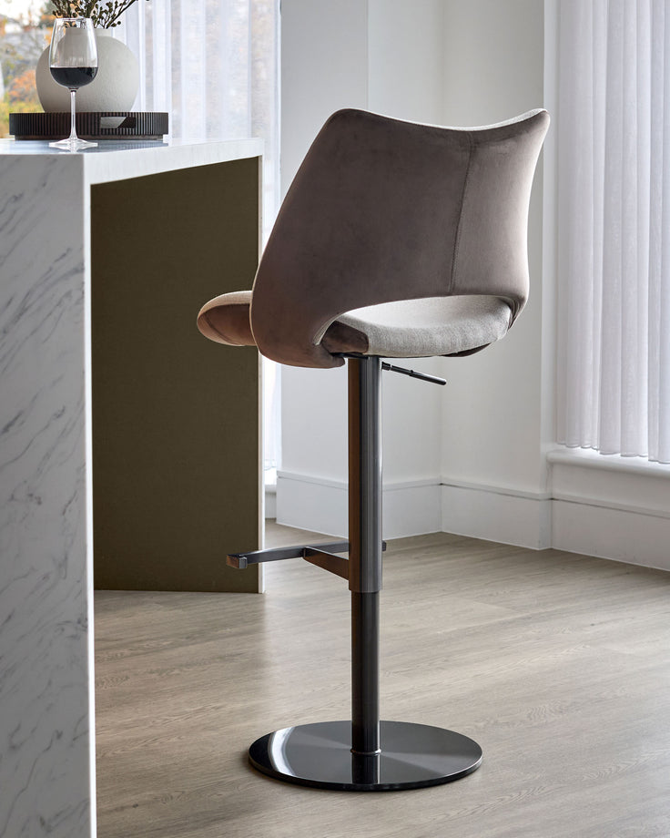 Bronwyn gas lift bar stool in mocha and natural velvet with black metal base, shown in modern interior setting.