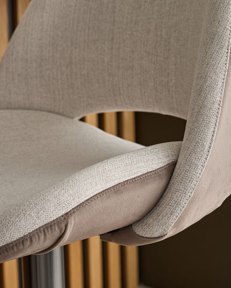 Bronwyn gas lift bar stool in natural fabric with mocha base, close-up detail of curved armrest and seat.