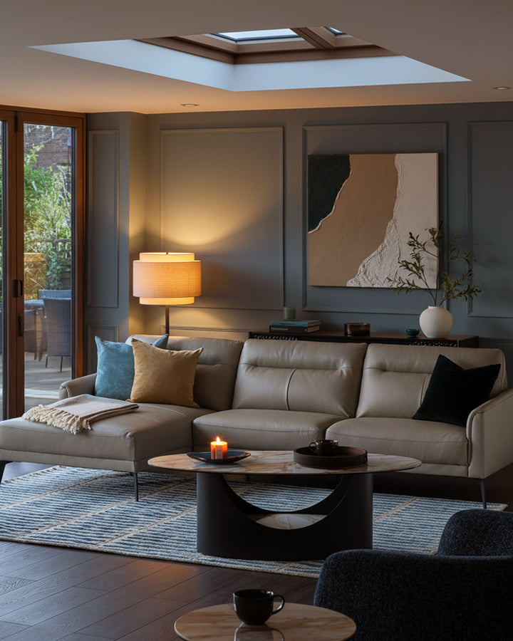 Brooks leather left-hand corner chaise sofa in light grey, displayed in a modern living room setting with cushions and throws.