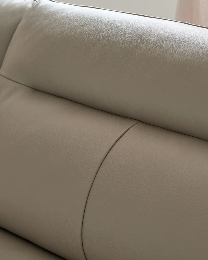 Light grey leather left-hand corner chaise sofa, close-up of curved seating section and armrest detail.