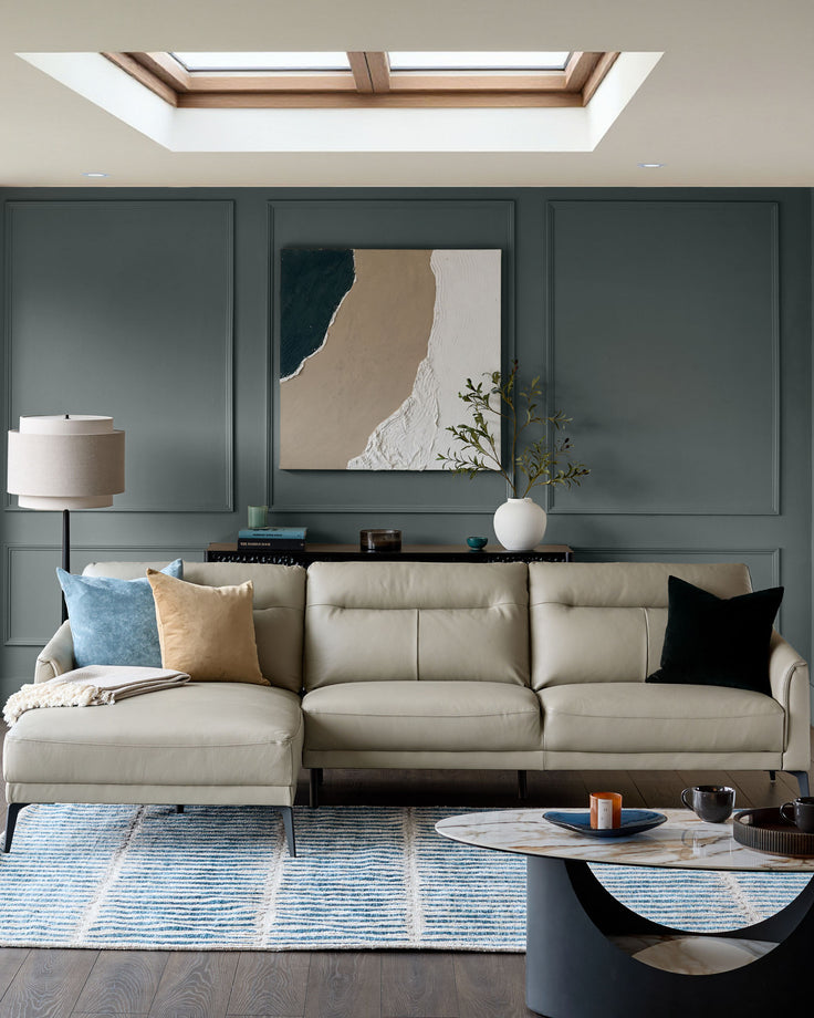 Light grey leather left-hand corner chaise sofa with rolled arms in a modern living room setting.