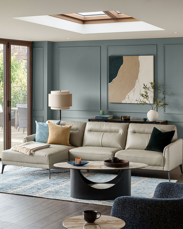 Brooks leather left-hand corner chaise sofa in light grey, styled in a modern living room with accent pillows.