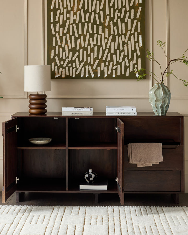 Dark mango wood sideboard with three open cabinet sections, metal handles, and decorative items displayed on top.