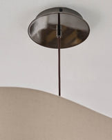 Brushed nickel ceiling canopy with dark rod suspending a natural linen drum shade pendant light.