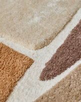 Close-up of a patterned rug with beige, brown, and cream stripes, showing the soft textures.