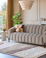 Stylish living room featuring a fluted sofa, geometric rug, and modern lamp. Light and airy, showcasing comfort and design.