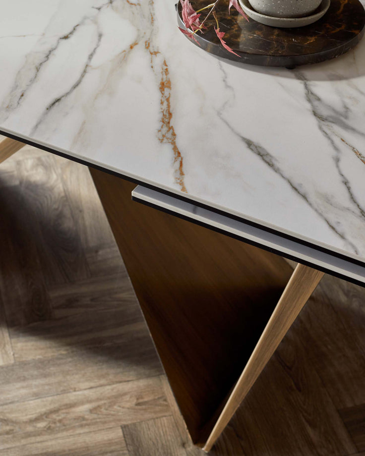Stylish dining table featuring a marble top with elegant veining and sleek wooden legs for a modern look.