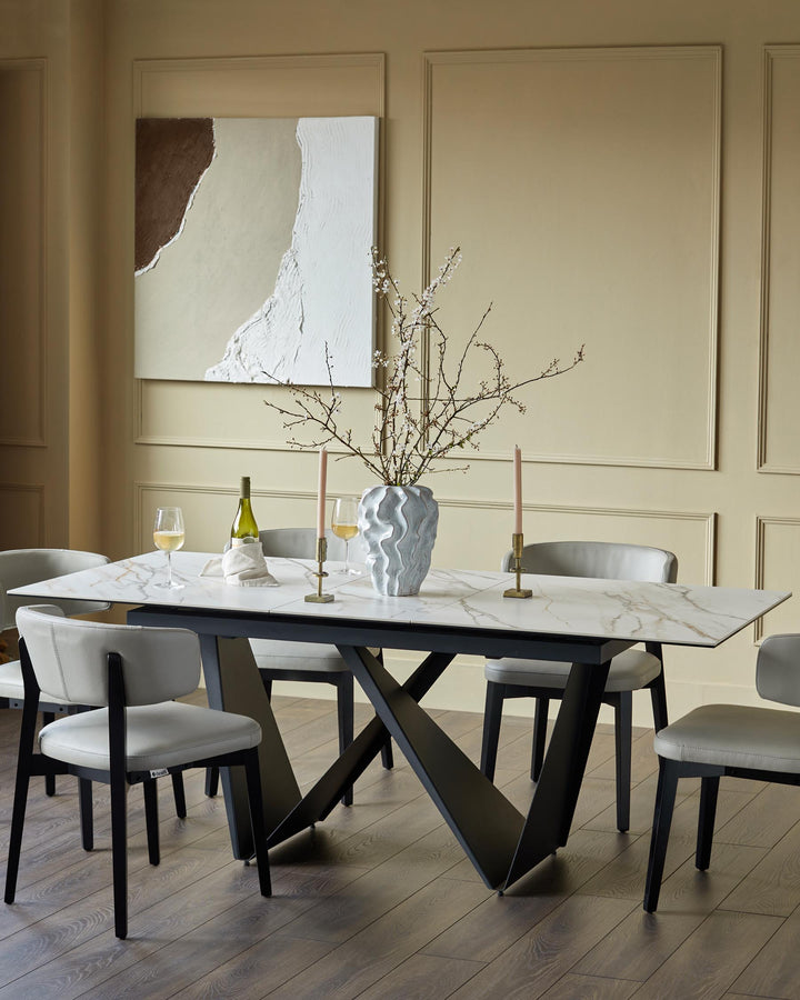 A contemporary dining set featuring a marble-effect table with a unique black base and six stylish grey chairs.