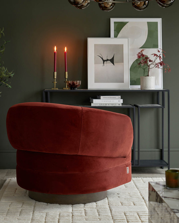 Stylish living room scene featuring a burnt orange swivel chair, console table and tasteful decor.