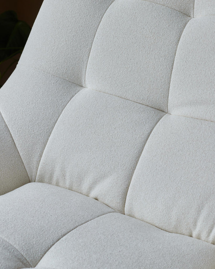 Close-up of a white, tufted, soft-textured sofa cushion. Modern design that looks comfy and stylish.