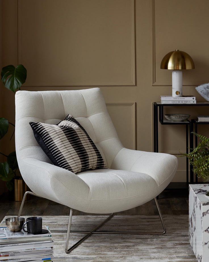 A stylish living space featuring a modern white armchair, complemented by a marble side table and sleek black shelving unit.