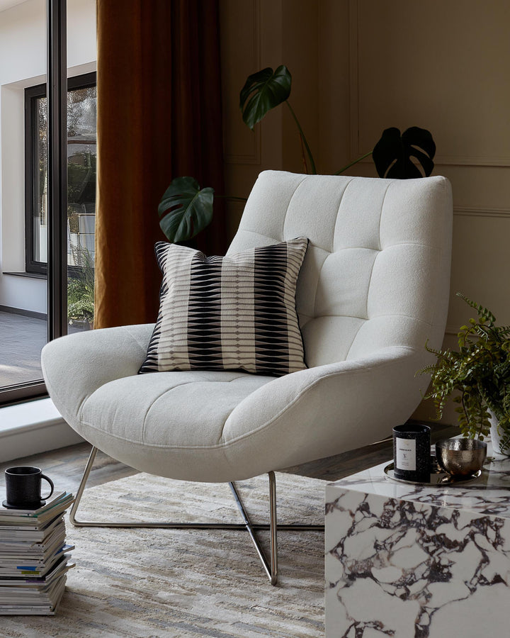 A stylish white armchair with a patterned cushion, complemented by a marble side table and house plants.