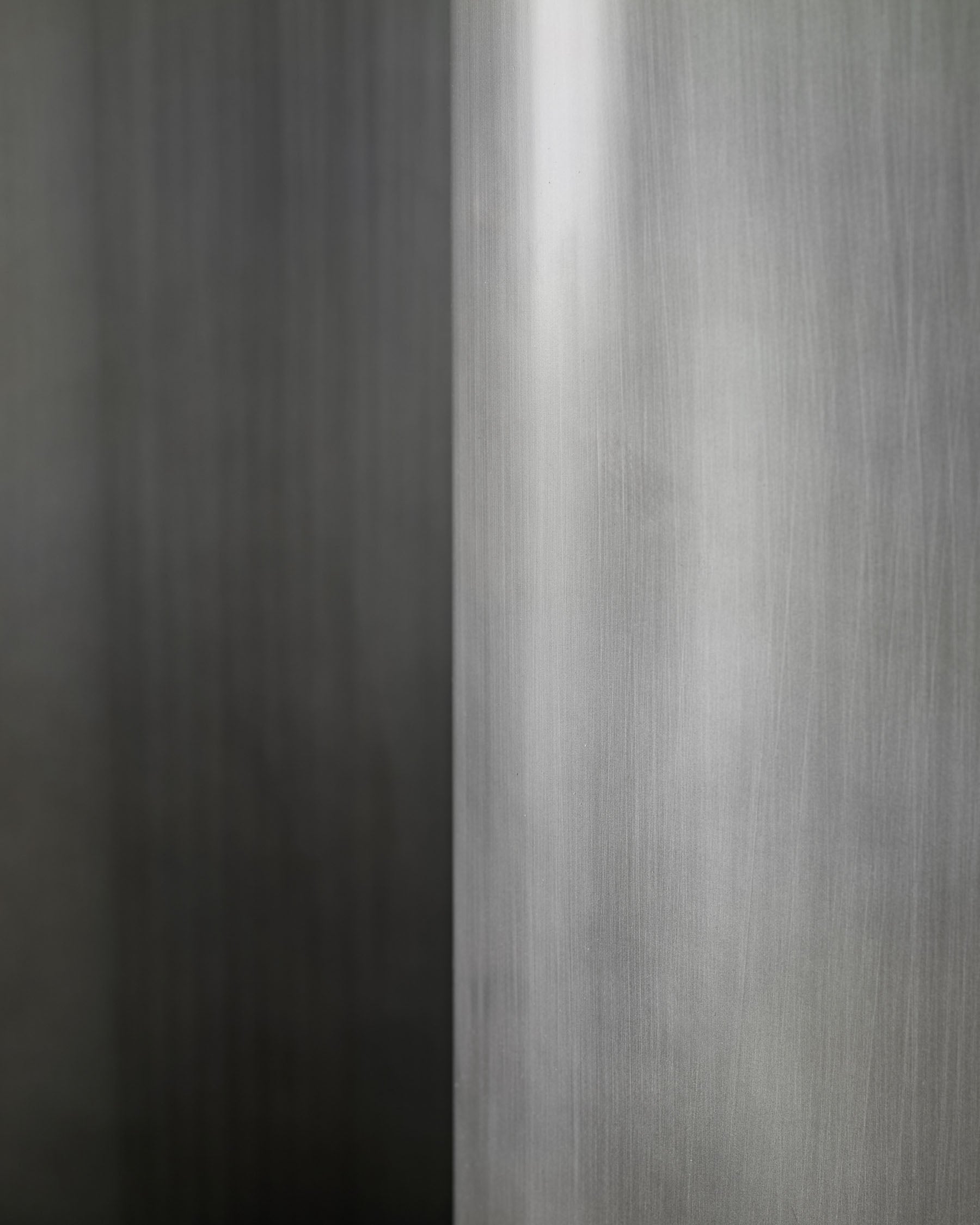 Close-up of brushed metal handle on Carlo 8-seater dining table with dark grey ceramic top