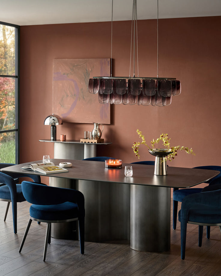Rhett dining chair in dark navy velvet, shown in modern dining room setting at table.