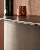 Carlo console table in dark grey ceramic with stainless steel trim, featuring a polished top surface and textured base.