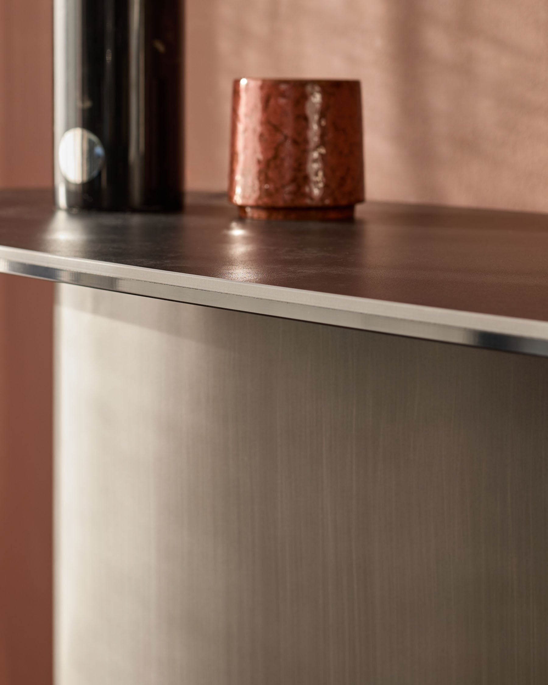 Carlo console table in dark grey ceramic with stainless steel trim, featuring a polished top surface and textured base.