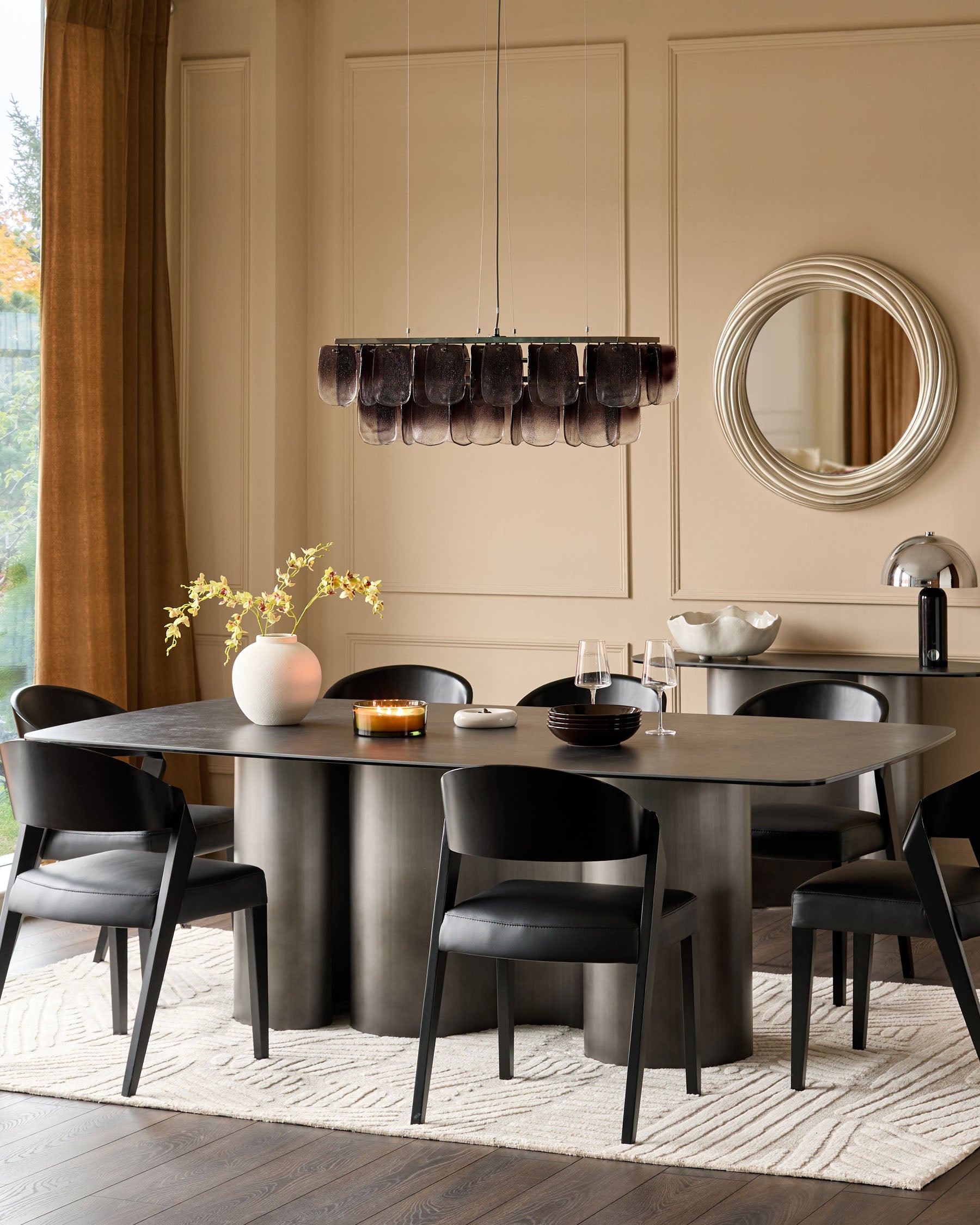 Carlo 8-seater dining table in dark grey ceramic with curved pedestal base, styled in modern dining room setting.