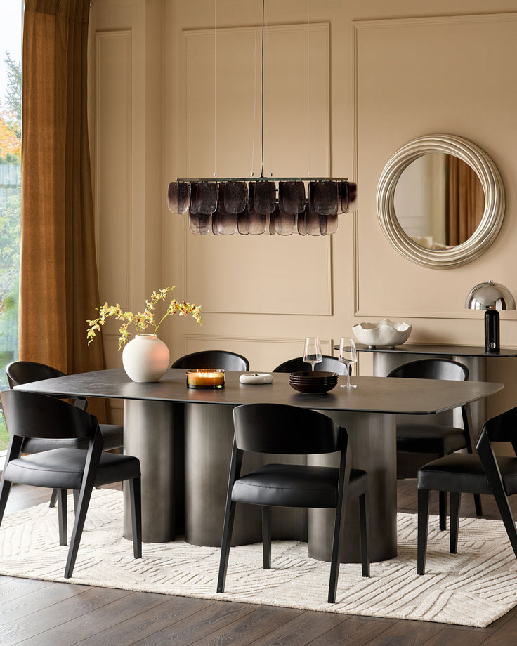Carlo 8-seater dining table in dark grey ceramic with curved pedestal base, styled in modern dining room setting.
