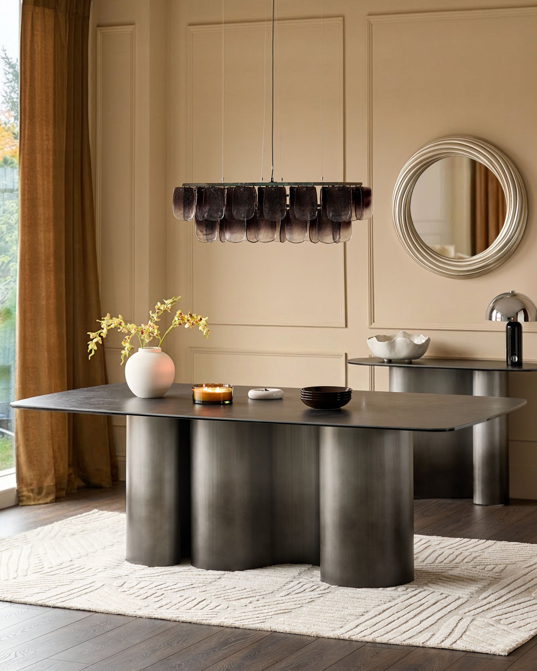 Carlo 8-seater dining table in dark grey ceramic with cylindrical metal base, shown in modern dining room setting.