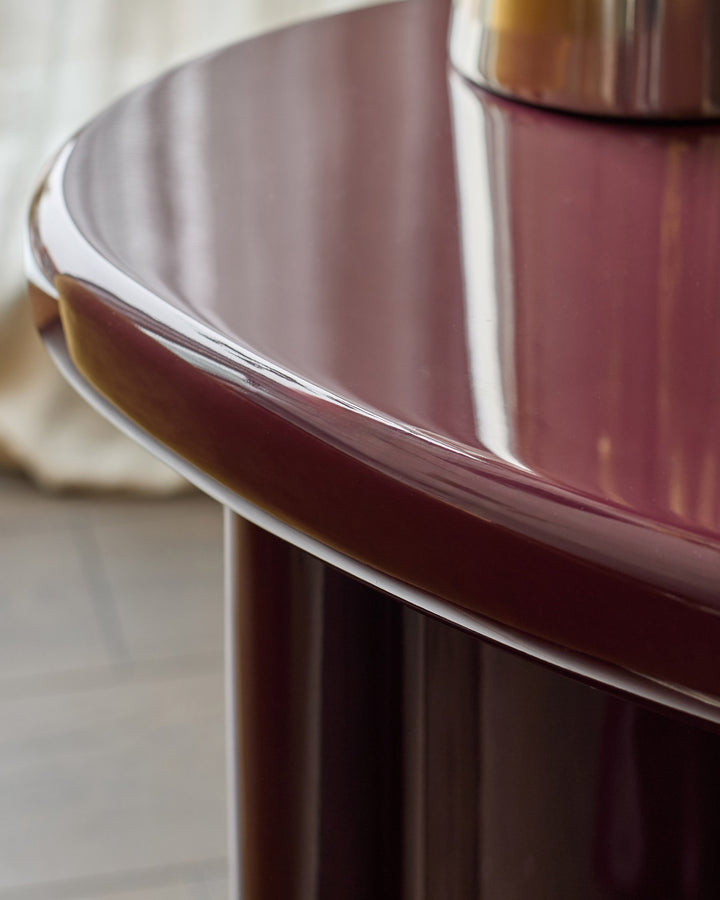 Gloss plum side table with curved edges and reflective finish, detail view of curved rim and base.