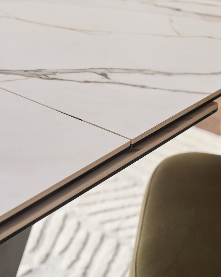 Close-up of the extending dining table's metal handle and marble-effect ceramic top surface.