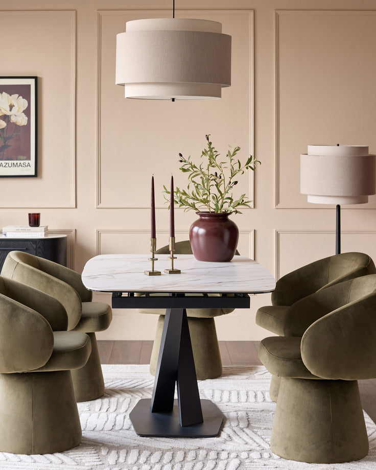 Carter extending dining table in natural ceramic with black pedestal base, shown in modern dining room setting.