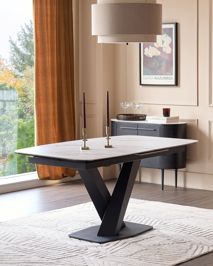 Carter extending dining table with black base and white marble top, seats 6-8, shown in modern dining room setting.
