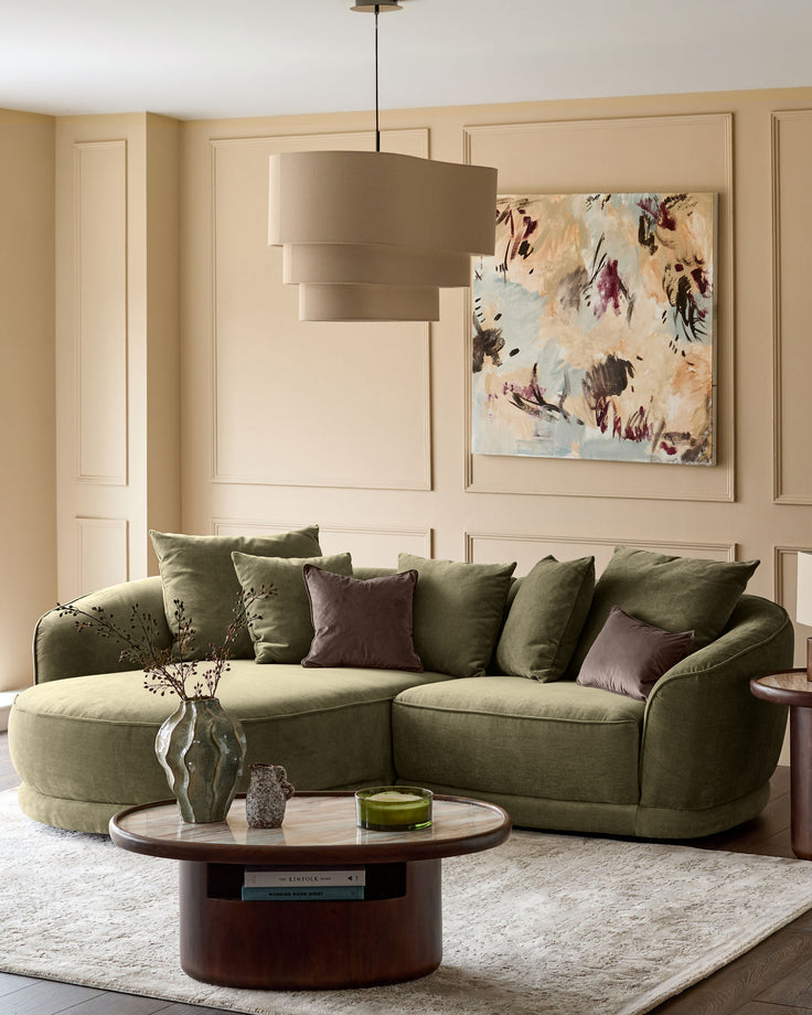 Olive green left-hand corner chaise sofa with curved arms and plush cushioning in a styled living room setting.