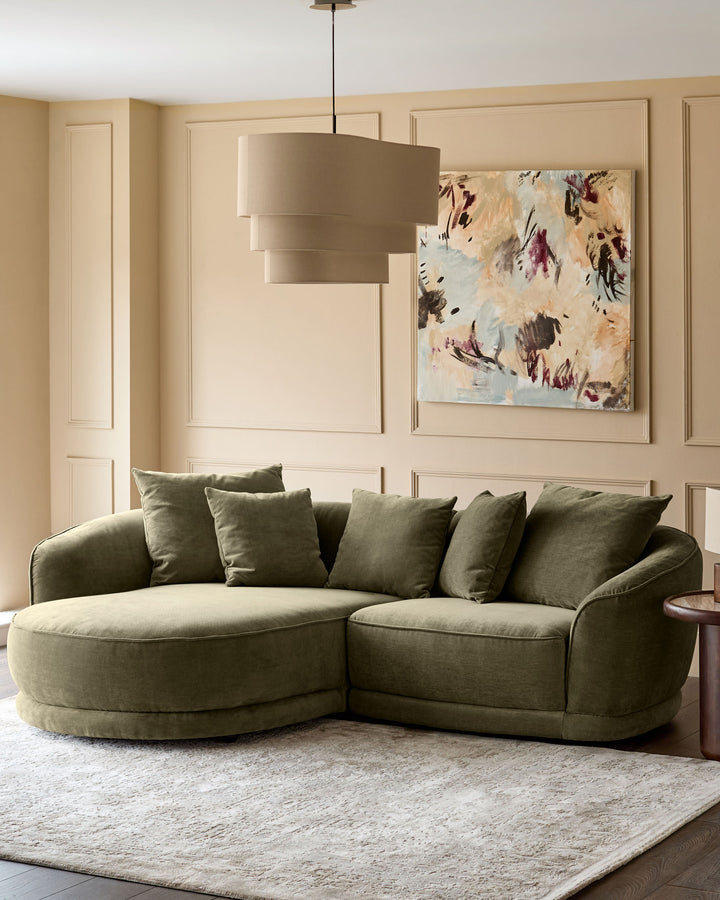 Caspian left-hand corner chaise sofa in olive green fabric, styled in a warm, neutral living room with coordinating pillows.