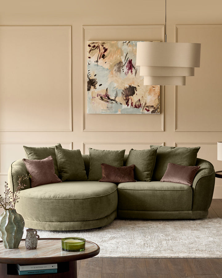 Caspian left-hand corner chaise sofa in olive green fabric, styled with burgundy and green cushions in a neutral living room setting.