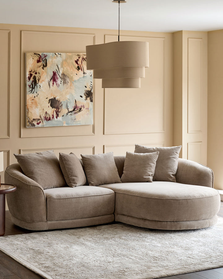 Caspian right-hand corner chaise sofa in mink fabric, curved design with rounded arms and multiple cushions in a neutral living room.