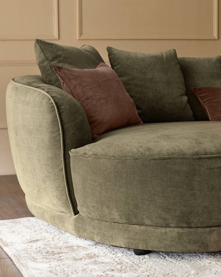 Caspian single module fabric sofa in olive green with decorative burgundy and green pillows, curved armrest detail visible.