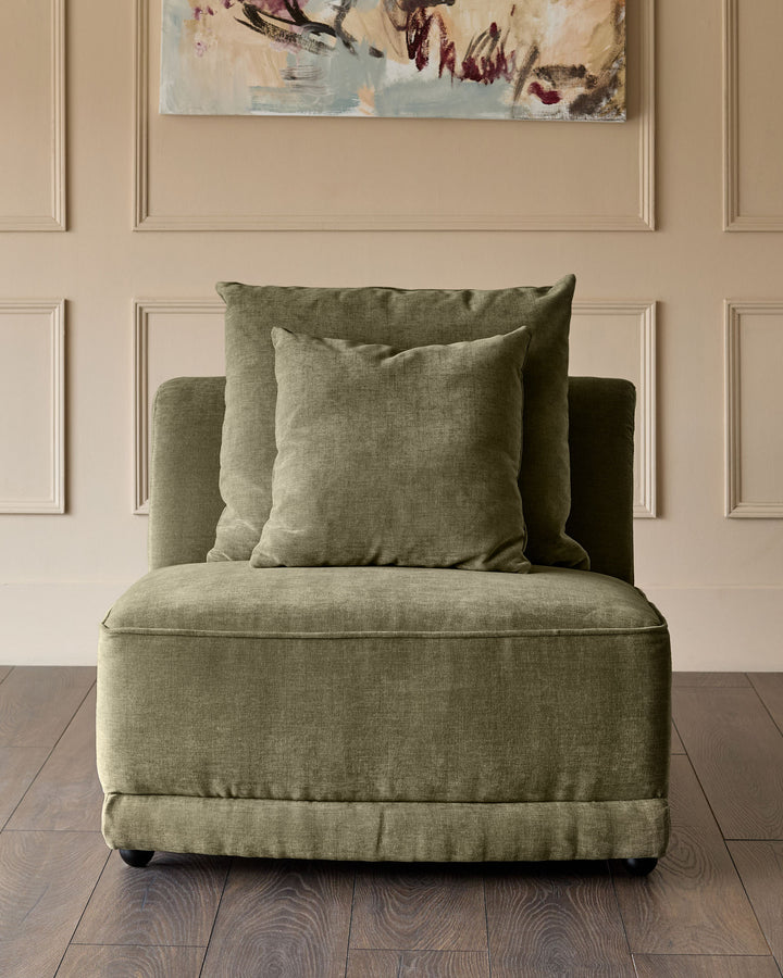 Caspian single-module fabric chair in olive green with matching throw pillows, displayed against a beige paneled wall.