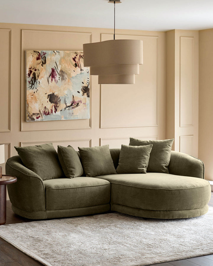 Caspian right-hand corner chaise sofa in olive-green fabric with curved design and decorative pillows in a styled living room.