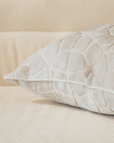 Ivory quilted cushion with geometric pattern, shown from side angle on neutral background.