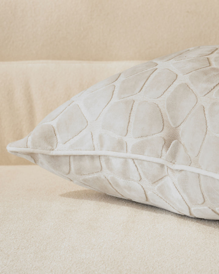 Ivory quilted cushion with geometric pattern, shown from side angle on neutral background.
