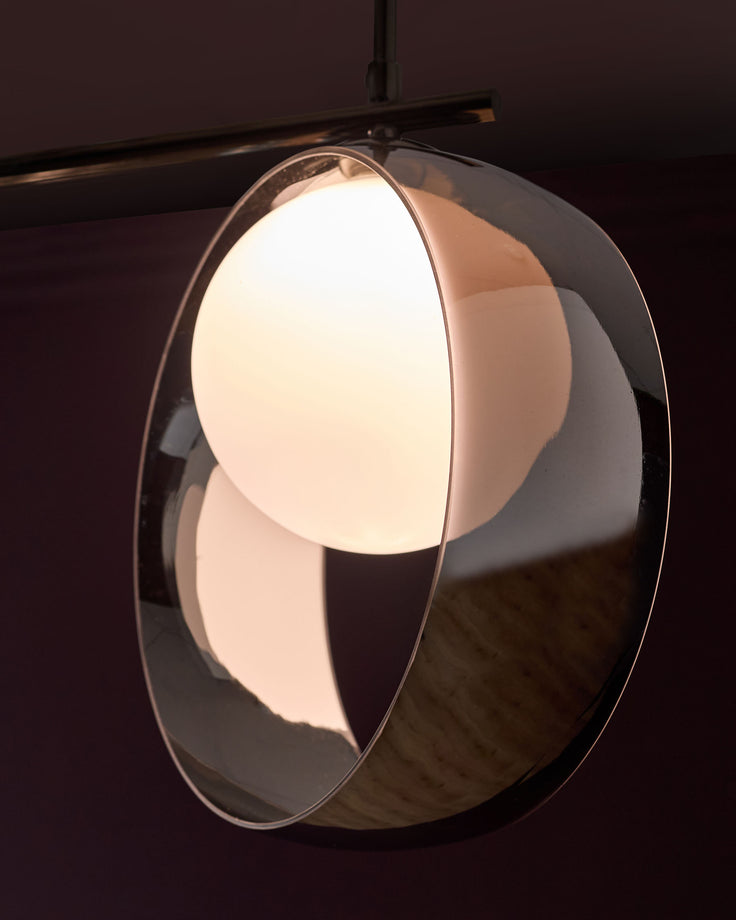 Chloe 3 pendant light with oval glass shade in silver chrome finish, illuminated against dark background.