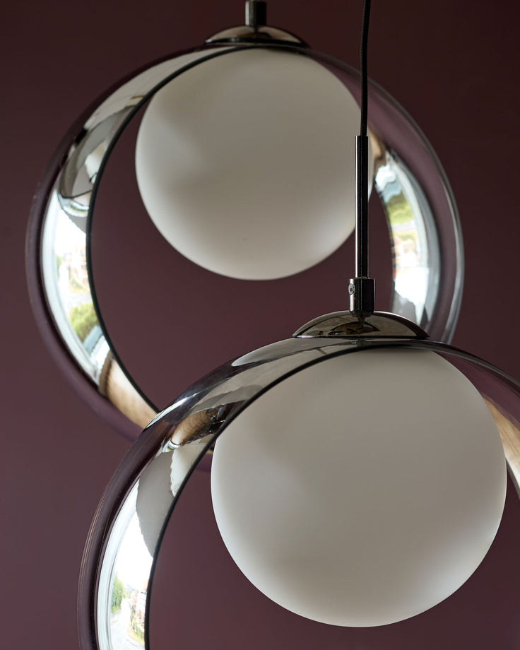 Chloe 4-pendant light with frosted glass spheres and polished chrome finish against burgundy background.